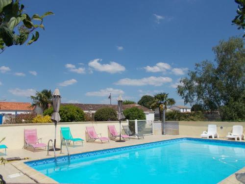 - une piscine avec des chaises longues dans l'établissement Le Clos des Palmiers, à Saint-ouen-dʼAunis