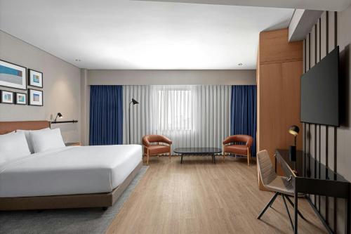 a hotel room with a bed and a table and chairs at Four Points by Sheraton Istanbul Pendik in Istanbul
