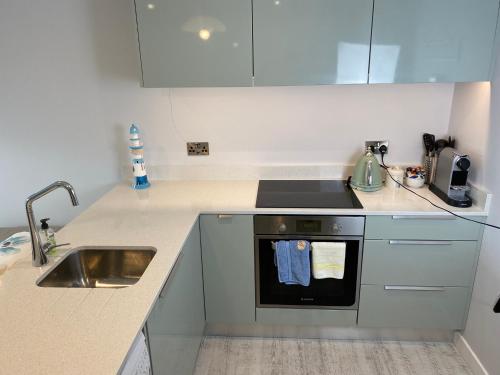 a kitchen with a sink and a stove at The North Cove, 20m to the Sea, Modern Studio Apartment in Portrush