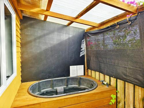 a hot tub in a room with a black wall at Parakai Geothermal Motel in Parakai