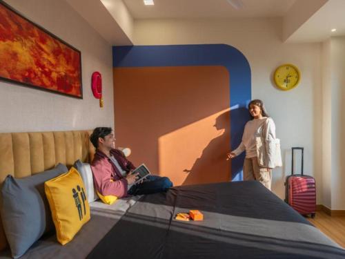 a woman sitting on a bed in a room at The Hosteller Amritsar, Near Golden Temple in Amritsar