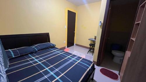 a bedroom with a bed and a bathroom with a toilet at House of DHESSA in Butuan