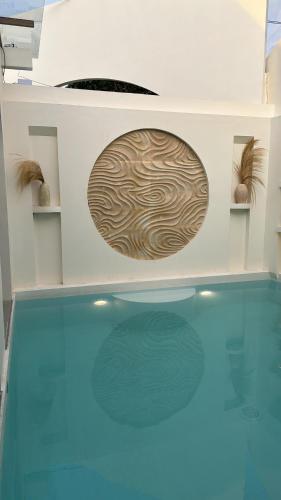 a swimming pool with a wooden circle on the wall at Fulton Villa Alexandria 2BR in Sleman