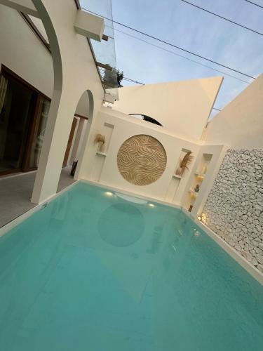a swimming pool in front of a house at Fulton Villa Alexandria 2BR in Sleman
