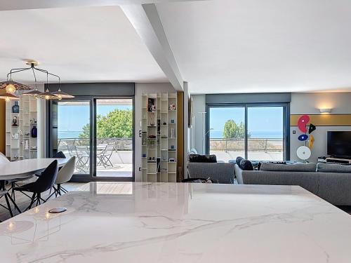 - un salon avec une grande table blanche et des chaises dans l'établissement Trois Plages Pleine Mer, à Royan