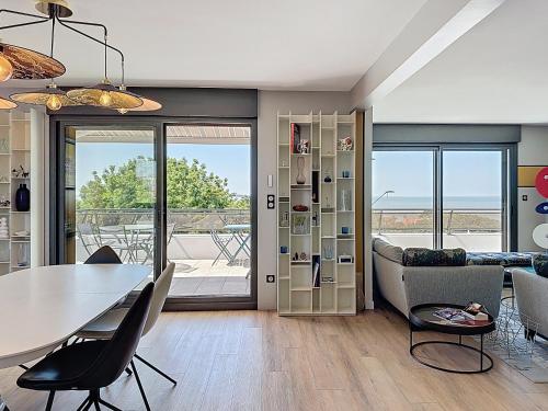 un salon avec une table, des chaises et un canapé dans l'établissement Trois Plages Pleine Mer, à Royan