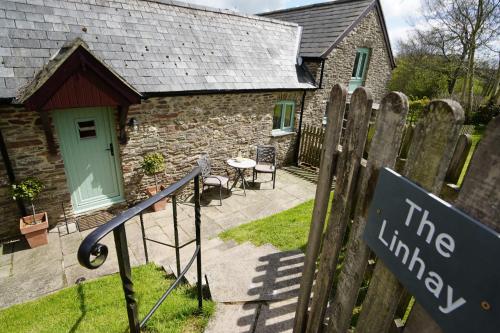 a stone cottage with a sign in front of it at The Linhay Nr Wiveliscombe in Wiveliscombe
