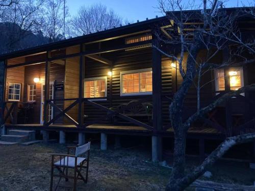 a log cabin with a bench in front of it at beau lac biwako annex in Takashima