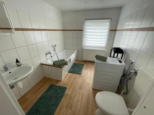a bathroom with a toilet and a sink and a tub at Trebelsee 2 Monteur- und Ferienwohnung in Ketzin
