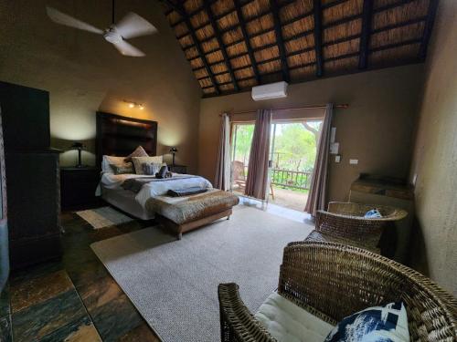 Un dormitorio con una cama y un sofá y una ventana. en Leopard Rock Guest Lodge, en Mica