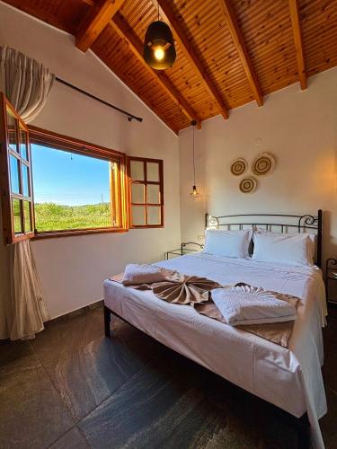 a bedroom with a large bed with a large window at MK Rustic Stays in Neos Marmaras