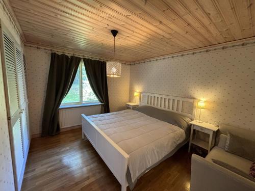 a bedroom with a large bed and a wooden ceiling at Villa Älghult in Älghult