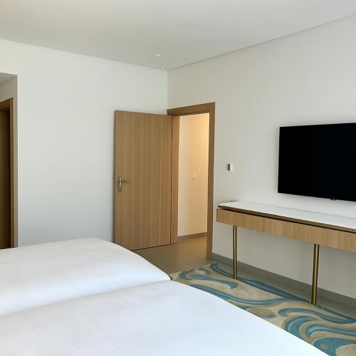a hotel room with a bed and a flat screen tv at Pickalbatros Palais Des Roses - Agadir - All Inclusive in Agadir