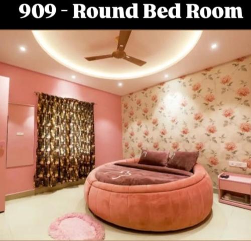 パンチガニにあるHotel Greek Glory,Panchganiのピンク色の部屋にある丸いベッドのある寝室