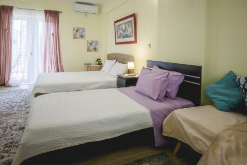 a hotel room with two beds with purple pillows at Καινούριο σπίτι σε ήσυχη τοποθεσία in Nafplio