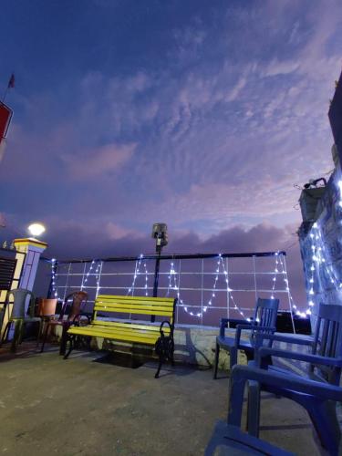 a group of benches sitting on a deck with lights at Kallal Resorts in Salem