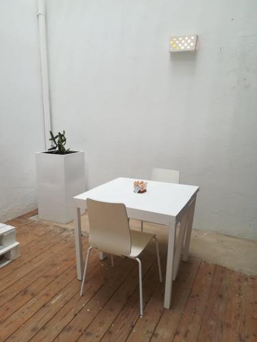 a white table with two chairs and a white wall at Appartamenti Praia Estoril, Sal Rei, Boa Vista in Sal Rei