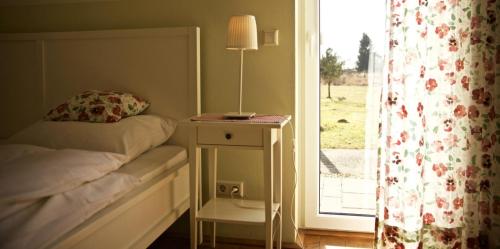 a bedroom with a bed and a table with a lamp at Ferienhausquartier Huberhof in Seehausen
