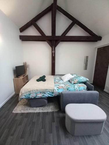 - une chambre avec un lit et un pouf dans l'établissement Le Nid de l'Artiste - Reims Cathedral City Center, à Reims