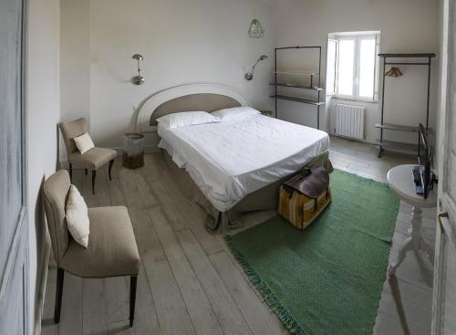 ein Schlafzimmer mit einem großen Bett und einem Stuhl in der Unterkunft Villa Vallecento con Giardino - Borgo Stays in Monterosi
