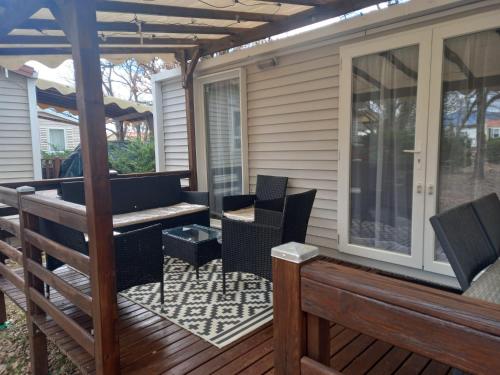 a patio with chairs and a table on a deck at Mobil home in Sainte-Croix-de-Verdon