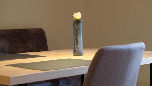 a vase with a flower in it sitting on a table at Grimmhof in Fiè