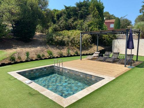 - une piscine dans une cour avec une terrasse en bois dans l'établissement GRIMAUD-Maison 4 Pers - Piscine, à Grimaud