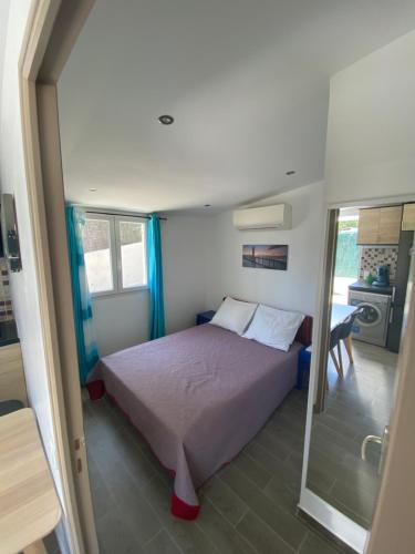une petite chambre avec un lit et un miroir dans l'établissement GRIMAUD-Maison 4 Pers - Piscine, à Grimaud