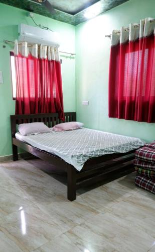 a bed in a room with red curtains at Bachhav Farm House in Katrab
