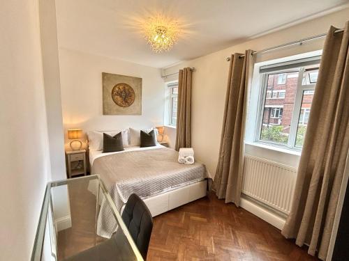 a small bedroom with a bed and a window at The Seraphina Suite - Chelsea in London