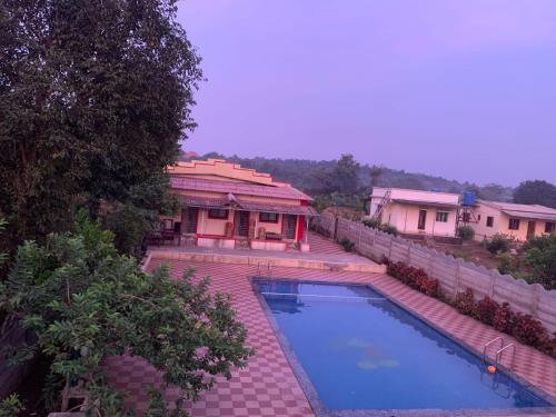 an overhead view of a house with a swimming pool at Bachhav Farm House in Katrab