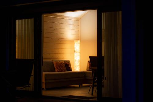a living room with a couch and a light at Greenland House in Cēsis