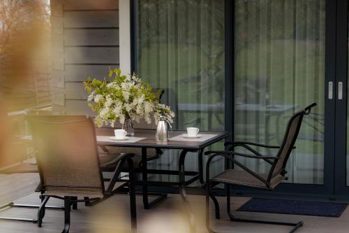 a table with two chairs and a vase with flowers at Greenland House in Cēsis