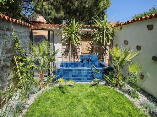 a house with blue stairs in a yard with palm trees at Meli Mila Spiti milozrooms Ayvalik in Ayvalık