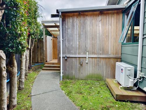 a door to a house with a fence at Parakai Geothermal Motel in Parakai