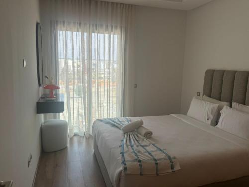a bedroom with a large bed with a large window at Appart idéal Face Gare Agdal in Rabat