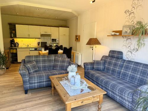 a living room with two couches and a table at Ferienhaus Blinkfuer in Neuharlingersiel