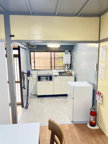 a kitchen with a refrigerator and a stove at サニーサイドホステル1号館 in Uji