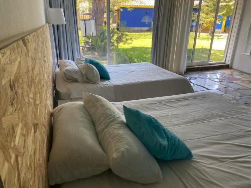 two beds with pillows in a room with a window at Jacaranda in Cádiz