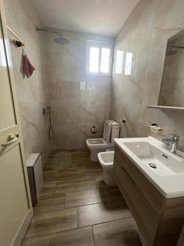 a bathroom with a toilet and a sink at FOUR L's in Arape-Rashbulli