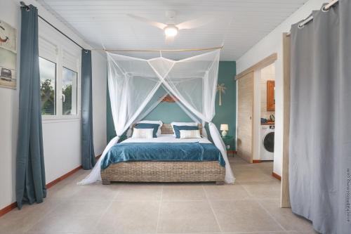 莱特鲁瓦西莱Villa KANOA - T2- classé 4 étoiles - Vue Mer - Piscine - SPA的带天篷床的卧室