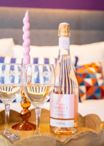 a bottle of wine and two wine glasses on a table at Stylish and Spacious 3-Bed House Free Parking in Ipswich