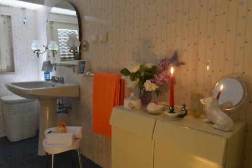 a bathroom with a sink and a counter with a candle at Basilicata Host to Host-Casa Eleonora in Pisticci