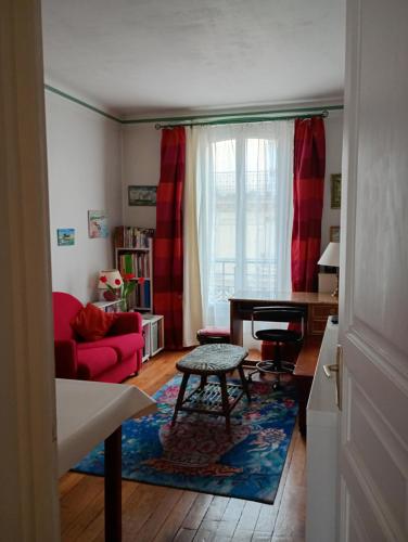 un salon avec un canapé rouge et une table dans l'établissement La maison rouge, à Paris