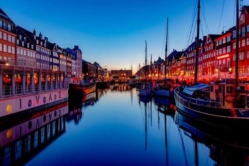 a harbor with boats in the water with buildings at Prime Location - Near Nyhavn & Tivoli Gardens in Copenhagen