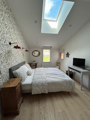 a bedroom with a bed and a desk and a window at Domaine les Hilliers in Bains-sur-Oust