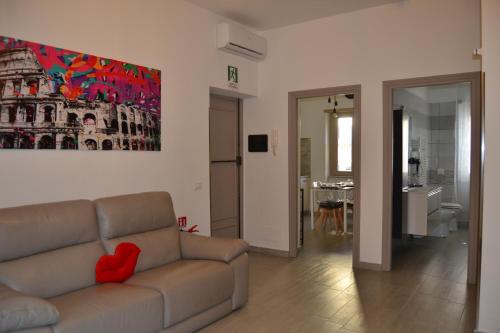 a living room with a couch and a painting on the wall at Casa Rolland in Acilia
