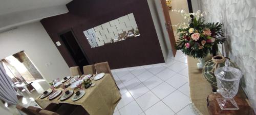 a room with a table and a vase of flowers at Casa de frente para o mar in Mucuri