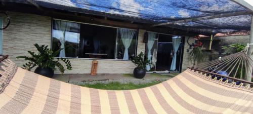 a hammock in front of a house at Casa de frente para o mar in Mucuri