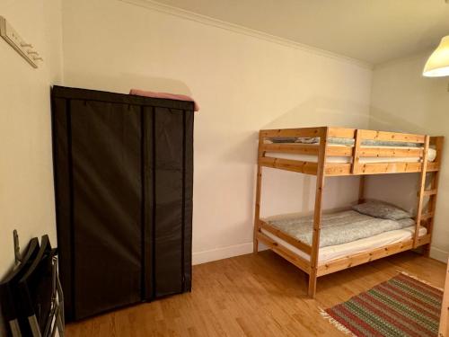 a room with a bunk bed and a black closet at Hässlebogården Turist & Konferens in Mariannelund
